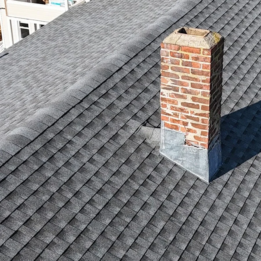 gal6 Brick chimney rising from a gray asphalt shingle roof
